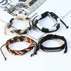 Handmade vintage woven leather bracelets set for men featuring metal quote charm on white background