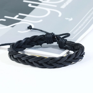 Detail of hand-woven black leather bracelet with adjustable sliding knot on magazine