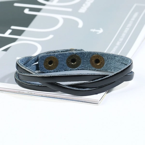 Vue détaillée du bracelet en cuir tressé noir multicouche avec boutons-pression en bronze