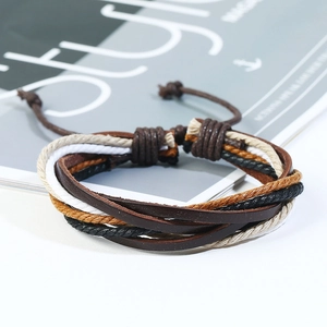 Detail of layered woven leather bracelets with adjustable drawstrings on a fashion magazine