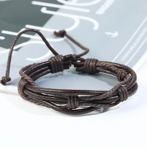 Dettaglio del bracciale multistrato in pelle intrecciata marrone scuro con nodo regolabile