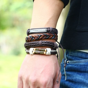 Close-up of retro multilayer braided leather bracelets with inspirational metal plate