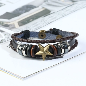 Close-up of retro braided leather bracelet with bronze star and metallic bead charms