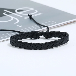 Gros plan sur un bracelet en cuir tressé noir avec nœud coulissant ajustable sur fond blanc