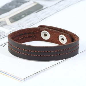 Close-up of deep brown leather bracelet with double orange stitching and metal snaps