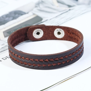 Vista dettagliata del bracciale in pelle marrone scuro con ricamo geometrico a due file