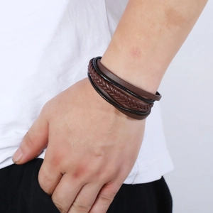Detaillierte Ansicht des mehrlagigen Lederarmbands am Handgelenk eines Mannes
