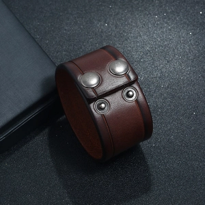 Macro view of wide brown vintage leather bracelet with adjustable silver snap buttons