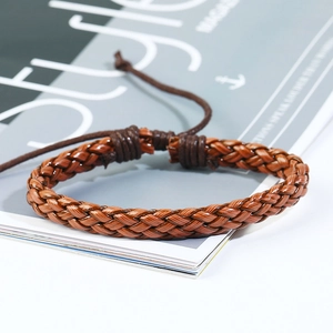 Vista macro del bracciale in pelle intrecciata marrone scuro con nodo a cordoncino