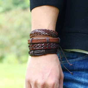 Detail of four-piece layered men's braided leather bracelets set in brown and tan tones