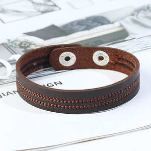 Detail of dark brown leather bracelet featuring double-row stitching and silver snap buckles