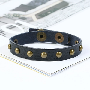 Détail du bracelet punk en cuir noir avec rivets en bronze et fermoir pression