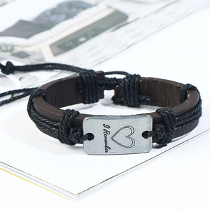 Détail d'un bracelet en cuir tressé marron avec plaque gravée I Remember