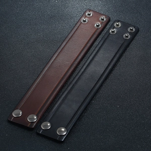 Detail of vintage leather bracelets in black and brown with adjustable silver snaps