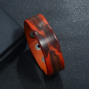 Detail of vintage wide leather bracelet with brown dye texture and adjustable metal snaps