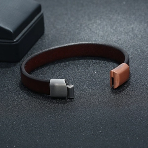 Men's brown leather bracelet with two-tone magnetic clasp on black background