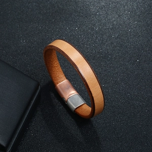 Detailed macro view of caramel leather bracelet with dual-tone metal magnetic clasp
