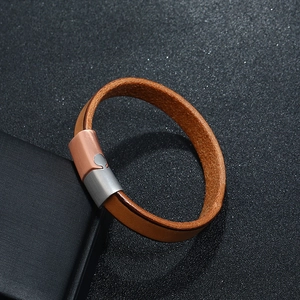 Men's brown genuine leather bracelet with dual-tone magnetic clasp on textured grey background