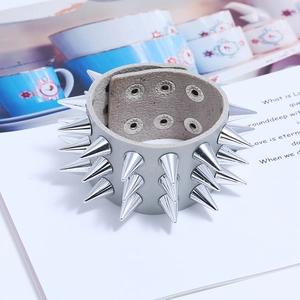 Vue détaillée du bracelet punk en cuir gris avec trois rangées de pointes en métal
