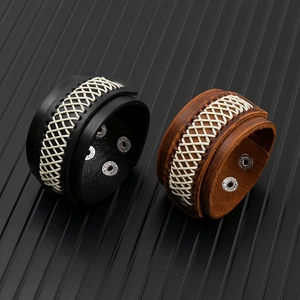 Detail of adjustable black and brown braided leather bracelets with metal press studs