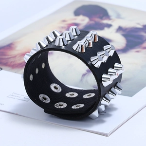Macro view of black leather punk bracelet featuring three rows of silver metal cone spikes