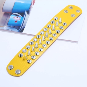 Detail view of yellow punk leather bracelet with three rows of silver metal cone spikes
