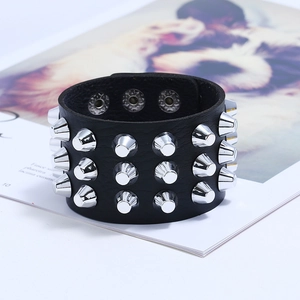 Detail showing three rows of silver metal cone studs on a wide black leather punk bracelet