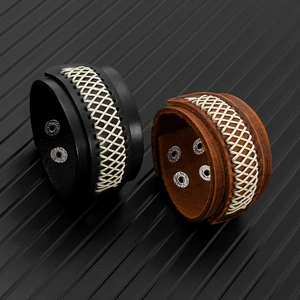 Close-up of woven diamond pattern on wide leather bracelets with adjustable silver snaps