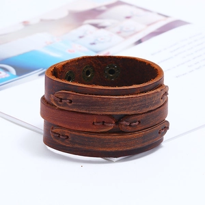 Detail van vintage leren armband met meerlagig stiksel en koperen drukknopen
