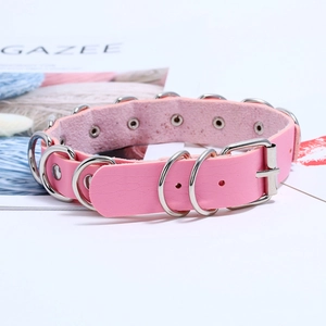 Close-up of pink leather choker with multiple silver metal rings and pin buckle