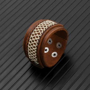 Macro detail of brown leather bracelet showing woven fiber patterns and metal snap fasteners