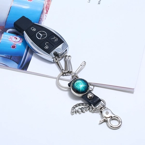 Detail of leather zodiac keychain with Taurus glass dome on a car key fob