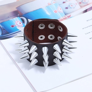 Détail d'un large bracelet punk en cuir avec trois rangées de pointes en métal argenté