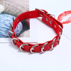 Close-up of red punk leather choker with silver D-rings and adjustable metal buckle