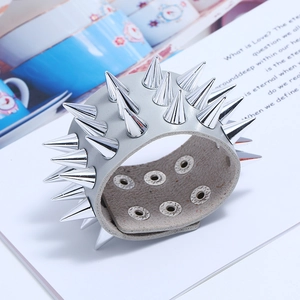 Vue détaillée des pointes argentées à trois rangées sur un bracelet punk en cuir gris