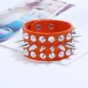 Macro shot of orange leather cuff bracelet with three rows of silver metal cone spikes