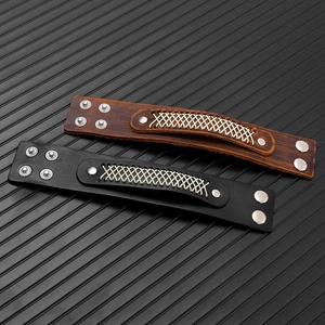 Detail of multi-layer woven leather bracelets in brown and black with silver metal snaps