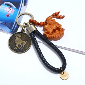 Macro detail of Aries zodiac leather keychain with vintage bronze horse pendant and beads