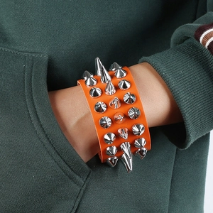 Orange punk rocker wide leather bracelet featuring four rows of sharp silver metal spikes