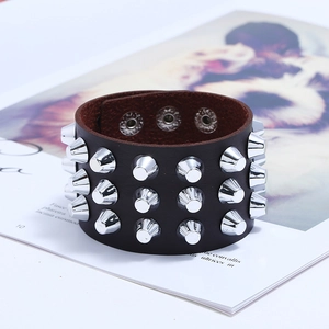 Close-up of punk leather bracelet with three rows of silver metal cone spikes and snap button