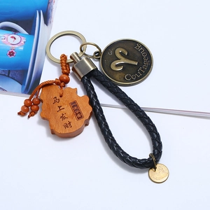 Braided leather keychain with Aries zodiac bronze disc and carved wooden lucky pendant