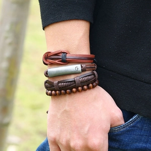 Vintage multi-layer leather bracelet set with metallic G-charm and wooden beads on wrist