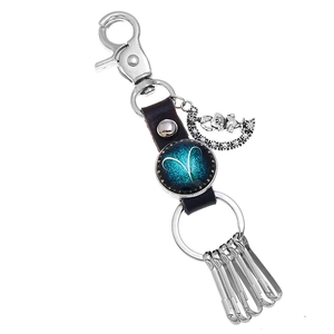 Close-up of Aries zodiac leather keychain with glass gem and crescent moon pendant