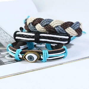 Three-piece bohemian braided leather bracelet set featuring evil eye bead and cord weave