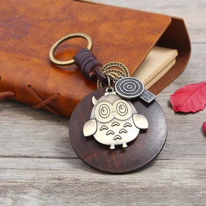 Porte-clés vintage en cuir tressé avec relief hibou et lanière en cuir marron sur bois