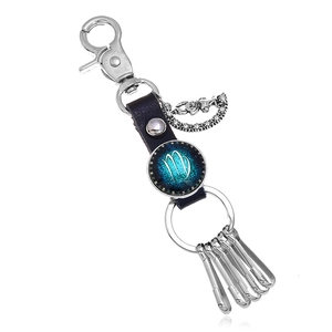 Detail of leather keychain with silver hooks and Virgo zodiac sign glass cabochon