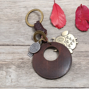 Porte-clés rétro en cuir tressé avec pendentif Totoro et disque bois sur fond bois