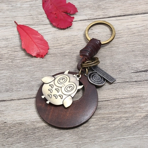 Porte-clés vintage en cuir tressé avec breloque hibou en bronze et disque en bois rustique