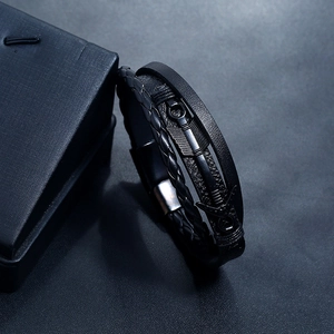Detail of multilayer black braided leather bracelet with arrow element and magnetic clasp