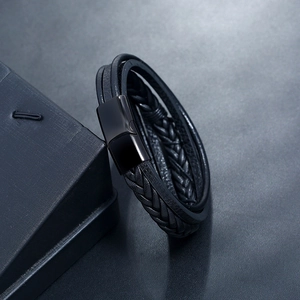 Detail view of multi-layer black braided leather bracelet with magnetic metal clasp